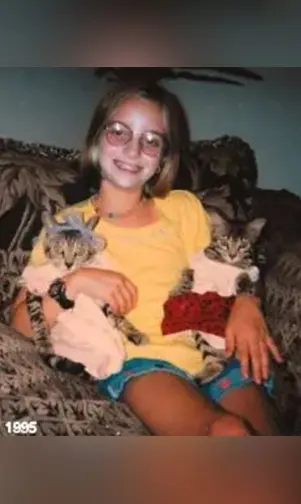 A girl sitting on the couch with two kittens.